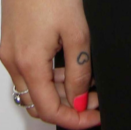Janel has heart shaped tattoo on her thumb