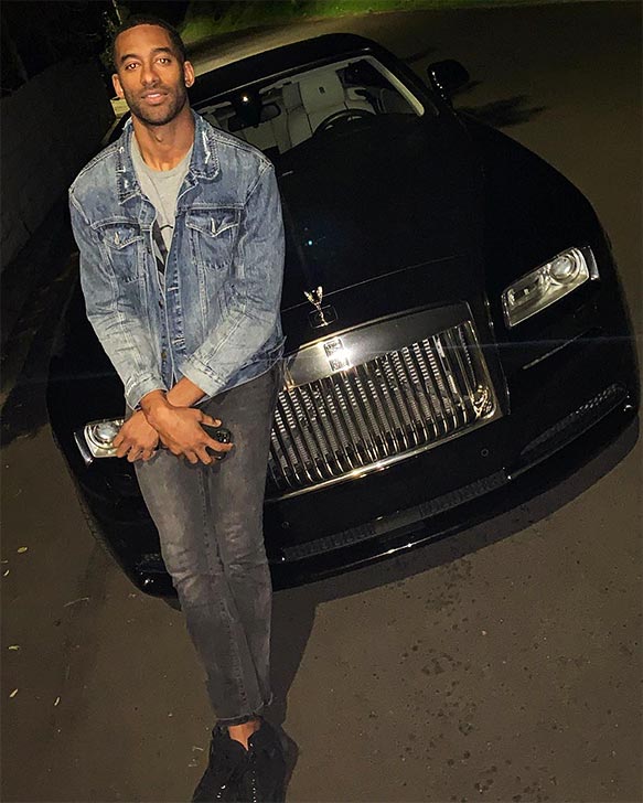 Matt in a denim jacket and jeans posing in front of Rolls Royce